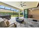 Screened-in patio has a cozy seating area with a fireplace, a hot tub, and views of the backyard at 8272 Summer Night Rd, Sarasota, FL 34241