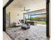 Covered patio features comfortable seating, a modern fireplace, and a relaxing hot tub with views of the backyard at 8272 Summer Night Rd, Sarasota, FL 34241