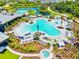 Aerial view of the large community pool with a water slide, tropical landscaping, and lounge chairs at 8272 Summer Night Rd, Sarasota, FL 34241