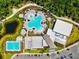 Aerial view of a large recreational pool area with sun loungers, lush landscaping, and ample parking at 8272 Summer Night Rd, Sarasota, FL 34241