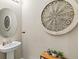 Stylish powder room featuring a pedestal sink, decorative mirror, and charming wall decor at 8272 Summer Night Rd, Sarasota, FL 34241