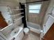 Compact bathroom with tub and shower, floating shelves and tiled walls at 8291 57Th N St, Pinellas Park, FL 33781