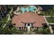Aerial view of community clubhouse and entrance featuring tile roof, beautiful entry, and lush landscaping at 8341 38Th Street Cir E # 303, Sarasota, FL 34243