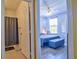 Bedroom view through bathroom doorway, showing bed, window, and blue decor at 8341 38Th Street Cir E # 303, Sarasota, FL 34243