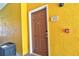 Exterior shot of unit 303's entry door in a yellow condo building at 8341 38Th Street Cir E # 303, Sarasota, FL 34243