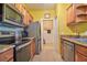 Galley style kitchen featuring stainless steel appliances and wood cabinetry against yellow walls at 8341 38Th Street Cir E # 303, Sarasota, FL 34243