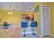 Open living area with kitchen, bar seating, desk area, wood floors, and yellow walls at 8341 38Th Street Cir E # 303, Sarasota, FL 34243