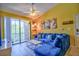 Cozy living room showcases a plush blue sofa, modern art, and a balcony access at 8341 38Th Street Cir E # 303, Sarasota, FL 34243