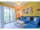 Cozy living room featuring a plush blue sectional couch and sliding glass doors to a balcony at 8341 38Th Street Cir E # 303, Sarasota, FL 34243