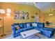 Bright living room with blue sectional, modern art, and view to adjacent kitchen/dining area at 8341 38Th Street Cir E # 303, Sarasota, FL 34243