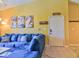 Comfortable living room with a blue sectional sofa, decorative wall art, and a bright yellow color scheme at 8341 38Th Street Cir E # 303, Sarasota, FL 34243