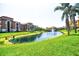 Scenic view of the pond surrounded by lush green grass, palm trees and buildings at 8341 38Th Street Cir E # 303, Sarasota, FL 34243