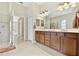 This bathroom features dual sinks, wood cabinets, and a walk-in shower at 9008 Brookfield Ter, Bradenton, FL 34212