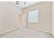 A bright bedroom with neutral walls, a window with blinds, and a carpeted floor leading to an open doorway at 9008 Brookfield Ter, Bradenton, FL 34212
