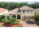 Beautiful two-story home featuring a tile roof, arched windows, and a well-manicured front yard at 9008 Brookfield Ter, Bradenton, FL 34212