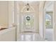 Bright foyer with decorative glass door, high ceilings, ceramic tile floors, and chandelier at 9008 Brookfield Ter, Bradenton, FL 34212