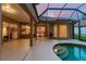 Covered patio featuring a swimming pool with rounded entry steps, and views into the kitchen, dining, and living room at 9008 Brookfield Ter, Bradenton, FL 34212
