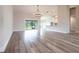 Open-concept living area with wood-look tile floors connecting to a bright kitchen and screened lanai at 9017 Province St, Sarasota, FL 34240