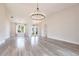 Bright living room featuring wood-look tile floors and a statement chandelier for an elegant touch at 9017 Province St, Sarasota, FL 34240