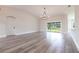 Spacious living area with wood-look tile flooring, modern lighting, and sliding glass doors at 9017 Province St, Sarasota, FL 34240