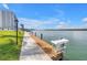 Private dock extends into the beautiful blue water, offering convenient access with grass and condominium in background at 9393 Midnight Pass Rd # 603, Sarasota, FL 34242