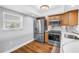 Kitchen with stainless appliances, wood floors, and a window view at 9393 Midnight Pass Rd # 603, Sarasota, FL 34242