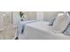 Light bedroom featuring ensuite bathroom, wood-look flooring, and neutral decor at 9822 Desoto Ct, Bradenton, FL 34210