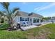 Charming waterfront home featuring a front patio with tropical landscaping and a grill at 9822 Desoto Ct, Bradenton, FL 34210