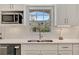 Close-up of a kitchen featuring white cabinets, stainless steel appliances, and a picturesque window view at 9822 Desoto Ct, Bradenton, FL 34210