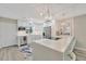 Modern kitchen featuring white cabinets, stainless steel appliances, large island, and stylish pendant lights at 9822 Desoto Ct, Bradenton, FL 34210