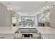 Kitchen cooktop overlooks the living area with pendant lights and quartz countertops at 9822 Desoto Ct, Bradenton, FL 34210