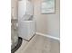 A bright laundry room featuring a stacked washer and dryer and space saving water heater at 9822 Desoto Ct, Bradenton, FL 34210