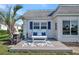 Cozy front patio featuring outdoor seating, a grill, and a charming tropical landscaping at 9822 Desoto Ct, Bradenton, FL 34210