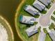 Overhead shot of residences near a pond, with one property having a swimming pool at 10030 Degas Ter, Bradenton, FL 34212