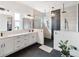 Modern bathroom with dual vanities, a glass-enclosed shower, and sleek black accents at 10030 Degas Ter, Bradenton, FL 34212