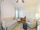 Bedroom with crib, comfortable chair, light colored wood floors and bright natural light at 10030 Degas Ter, Bradenton, FL 34212