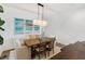 Bright dining room with wooden table, modern light fixture, and beach-themed artwork at 10030 Degas Ter, Bradenton, FL 34212