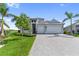 Beautiful two-story home with a three-car garage, lush landscaping, and a paver driveway at 10030 Degas Ter, Bradenton, FL 34212