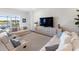 Bright living room with comfortable seating and large windows overlooking the backyard and pool at 10030 Degas Ter, Bradenton, FL 34212