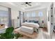 Bright main bedroom featuring a tray ceiling, wood floors, sitting area, and serene decor at 10030 Degas Ter, Bradenton, FL 34212