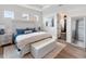 Well-lit main bedroom with a king bed, white furniture, and a glimpse into the ensuite bathroom at 10030 Degas Ter, Bradenton, FL 34212