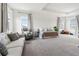 Spacious main bedroom with a tray ceiling, carpeting, neutral paint, and plenty of comfortable seating at 10030 Degas Ter, Bradenton, FL 34212