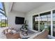 Covered patio with seating, sliding glass doors and a view of the pool and lake at 10030 Degas Ter, Bradenton, FL 34212