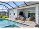 Backyard pool and hot tub with screened-in enclosure, overlooking the outdoor seating area at 10030 Degas Ter, Bradenton, FL 34212