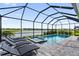Screened-in pool with spa overlooking lush landscape and a lake beyond at 10030 Degas Ter, Bradenton, FL 34212
