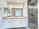 This primary bathroom has double sinks, bright lighting, and a glass-enclosed shower with tiled walls at 1053 Grantham Dr, Sarasota, FL 34234