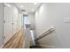 Hallway with carpeted stairs, wood flooring, and bright lighting leads to upstairs bedrooms at 1053 Grantham Dr, Sarasota, FL 34234