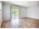 Sunlit living room with wood-look floors and glass sliding doors to the outdoor patio at 1053 Grantham Dr, Sarasota, FL 34234