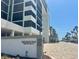 Beautiful exterior view of Lido Surf & Sand Beach Residences condo building with well-manicured landscaping at 1100 Benjamin Franklin Dr # 802, Sarasota, FL 34236