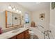 Bright bathroom with a wooden vanity, decorative mirror, and a combined tub and shower at 1190 Jamaica Rd, Venice, FL 34293
